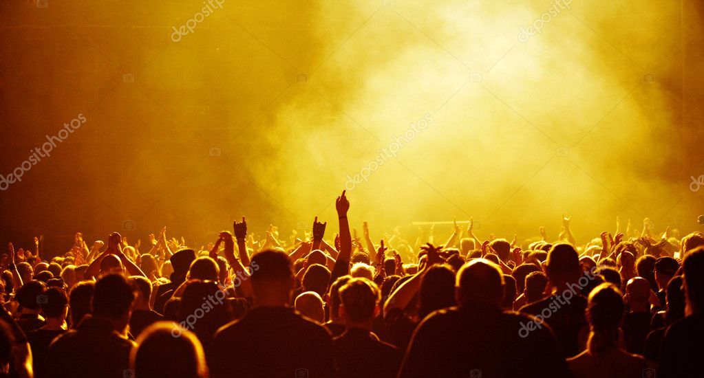 Festival musicale con palco illuminato e pubblico sotto il palco