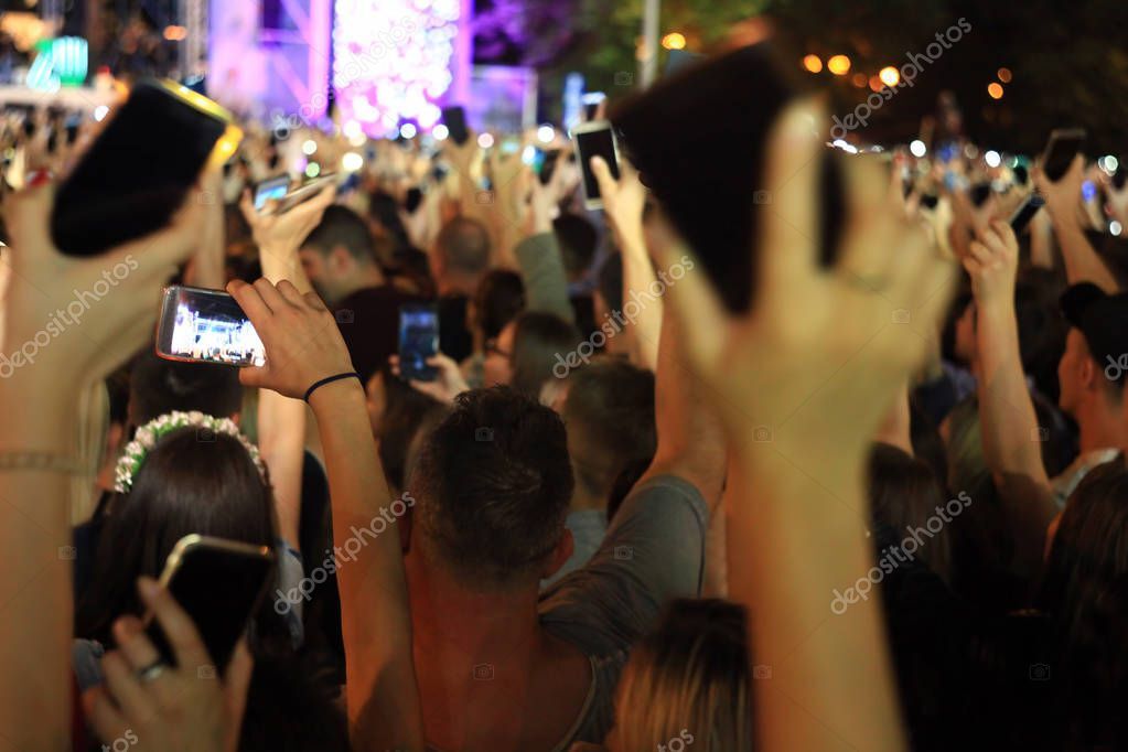 Locale notturno con palco, luci colorate e pubblico durante un concerto